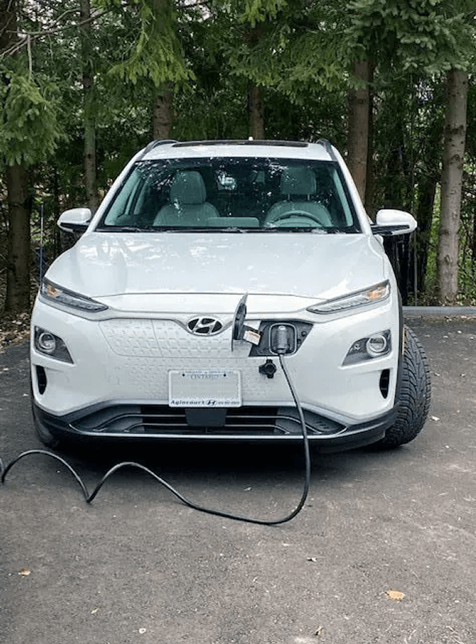 White electric vehicle plugged into power source