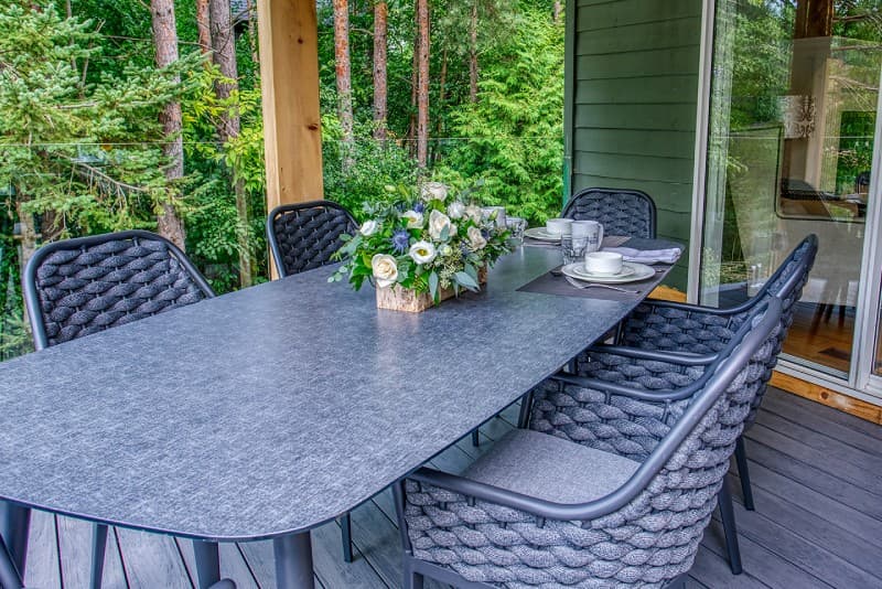 Horizontal patio table with flowers as centerpiece in front of Manor