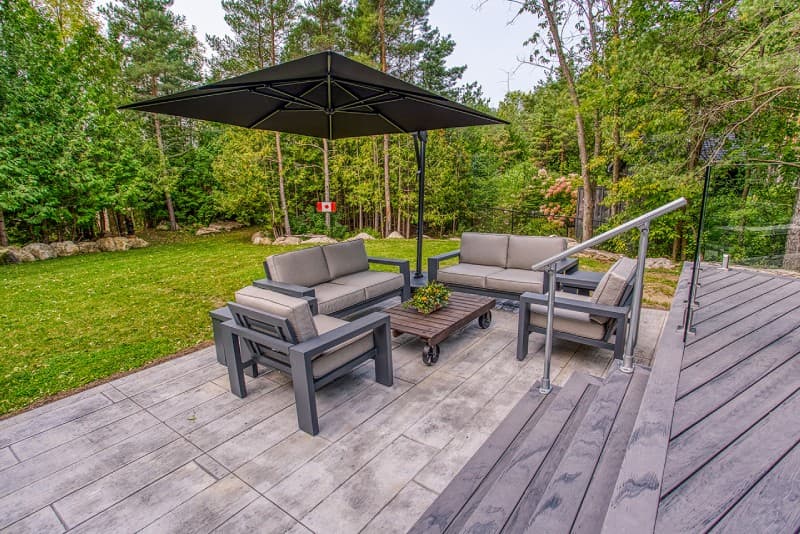 Patio furniture on lower level with brown umbrella