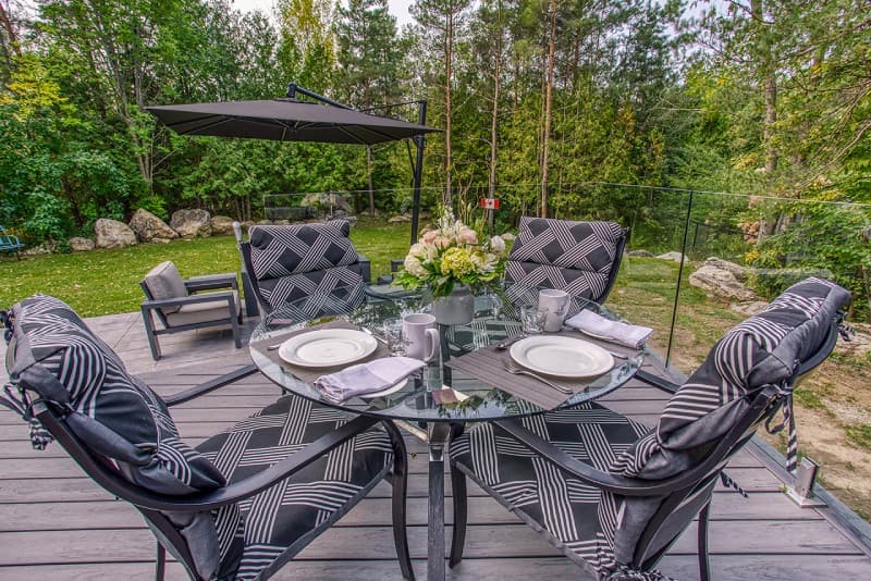 Patio chairs with padded seats on raised deck overlooking yard