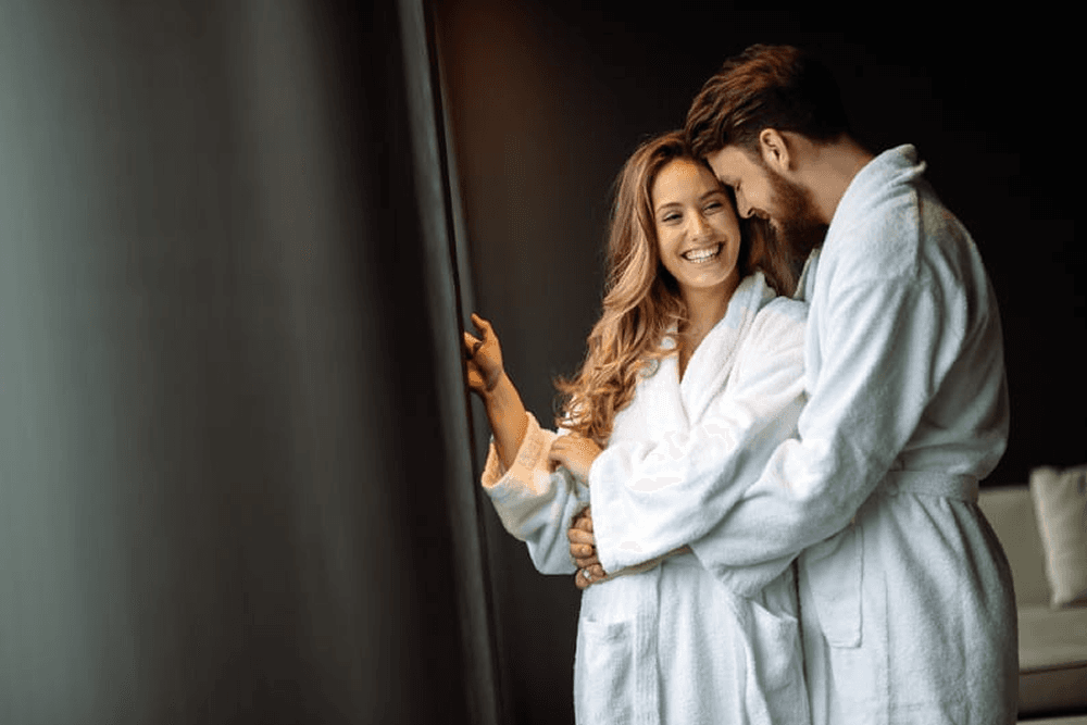 Man and woman in white robes with gray background