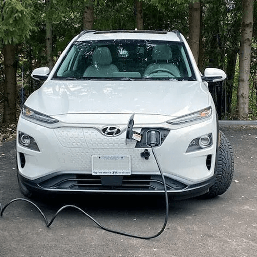 White electric vehicle plugged into power source