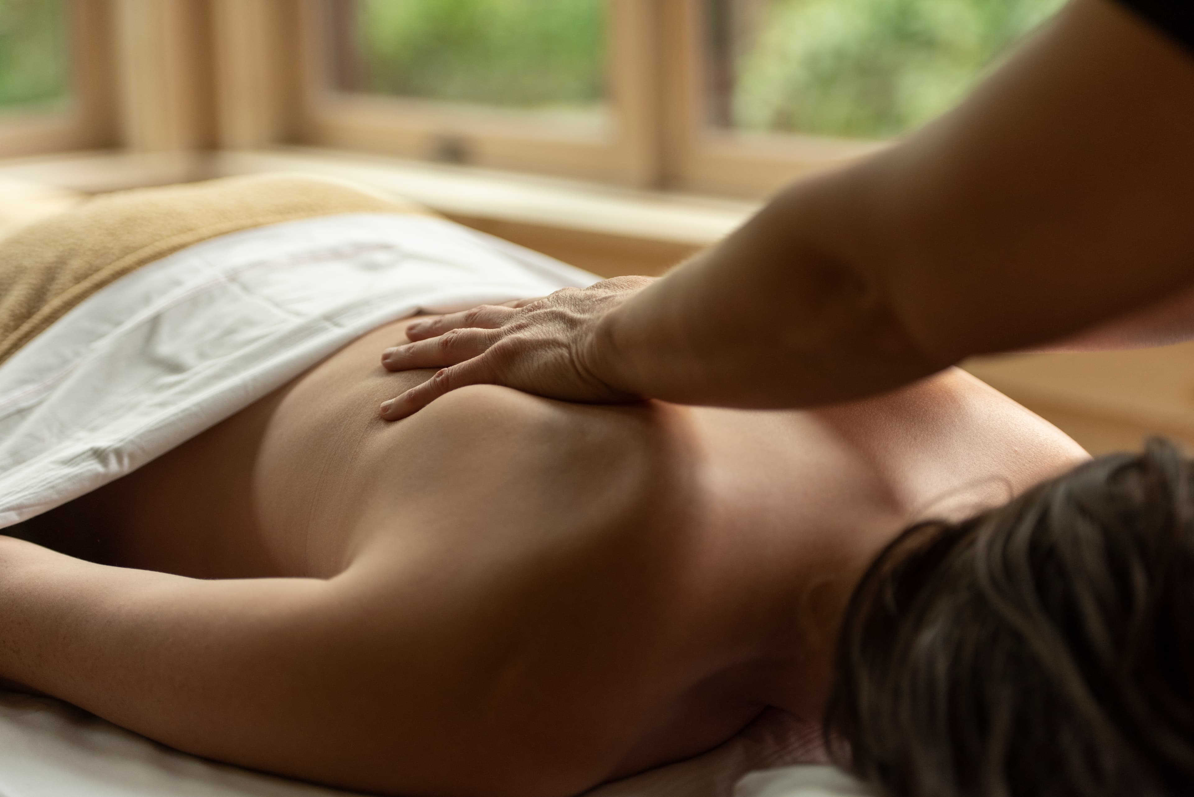 A person receives a massage in a serene indoor setting.