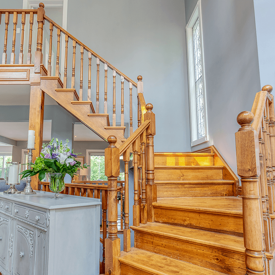 Curving oak grand staircase that leads to guest rooms